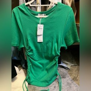 Good American green short sleeve tee shirt with sides that adjust.